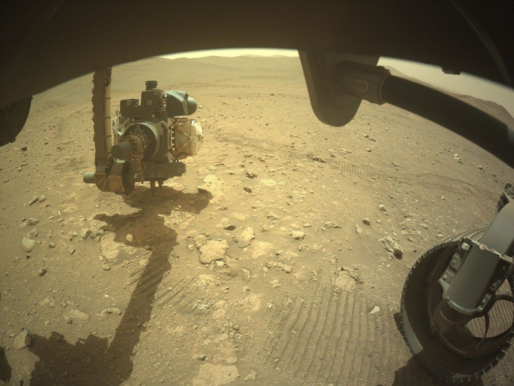 O rover Perseverance, da Nasa, usa instrumentos instalados em seu braço robótico para analisar uma formação rochosa na região de Idubi, em Marte, em setembro de 2026.